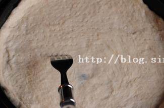 5、北极虾培根肉酱比萨,将面团分成2份，按照比萨盘的大小擀成合适的大小，有用叉子扎孔以防烤制时鼓起