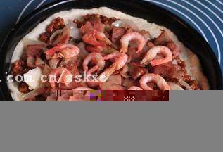 9、北极虾培根肉酱比萨,将蕃茄肉末铺在比萨饼底上，再均匀铺上培根和北极虾