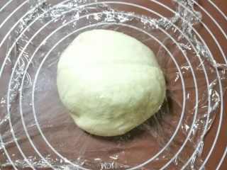 5、榴莲披萨,排气后盖上保鲜膜松弛5分钟。