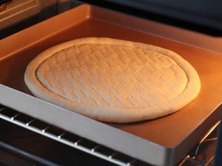 4、芝士榴莲披萨,烤箱上下火180度预热，将烤盘放入中层烤约13分钟。