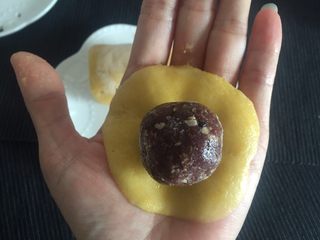 10、韩式南瓜????小月饼,在冷冻的南瓜圆柱面团上取21.5克面团用手压扁，中心略厚，边缘薄，饼皮大小以图中为宜