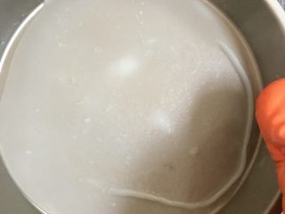 8、自制凉皮,蒸好的面皮稍微凉一点就可以取下来了。然后再舀入一勺面糊，继续蒸。