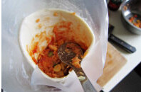 2、匹萨甜筒,飞饼皮上涂少许番茄，铺上些许馅料，包裹好，手握饼皮，用小勺子压实内陷