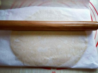 8、#感恩节食谱#嘻笑的熊宝宝饼干,静止后的面团放在案板上,上下各垫上一张油纸,用擀面杖将其擀薄,约2mm样子。