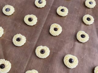 18、香酥曲奇花,在烘烤时准备第二种造型。顺时针以画圈的方式挤出后，在中央放置耐高温巧克力豆。