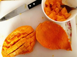 1、芒果慕斯,把芒果从中间切开，取出果肉