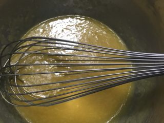 18、芒果慕斯,检查慕斯液凝固后就可以制作镜面了，一般冷藏一个小时左右就凝固了，吉利丁片2片，用冰水泡软备用。镜面的芒果泥加温水调匀。隔水加热搅拌，放入沥干水分的吉利丁片，搅拌至吉利丁完全融化就可以了。