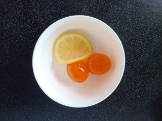 2、培根芝士披萨,敲2个咸鸭蛋，取出蛋黄，切一片柠檬，在蛋黄上滴几滴柠檬汁，也可换做白酒，可以去掉蛋黄的腥味。