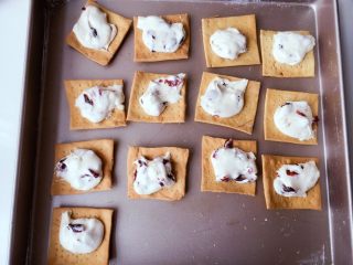 22、蔓越莓牛轧糖苏打饼干,趁热把牛轧糖放在苏打饼干上，我用小勺子挖的，没细算重量