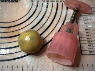 11、枣泥月饼,将面团压开后包裹好馅料，滚圆，拍粉，放入模具中。