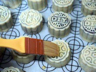 14、枣泥月饼,取出，表面刷上一层蛋黄水（1个蛋黄+1/4个蛋白混合均匀），放入继续210度烘烤5分钟。
