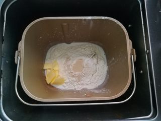 1、墨鱼热狗芝心披萨,把饼底食材放入面包机。