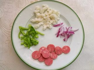 4、墨鱼热狗芝心披萨,把墨鱼、洋葱、甜椒切丝、热狗切片备用。