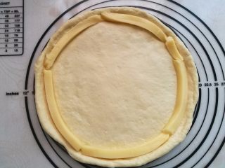 8、墨鱼热狗芝心披萨,把条状芝士围在盘边。