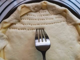 10、墨鱼热狗芝心披萨,用叉子在饼底刺孔。