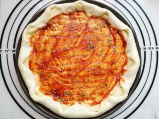 12、墨鱼热狗芝心披萨,撒上少许披萨草。