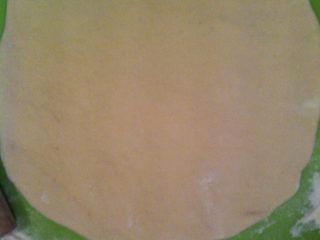 11、自制意大利pizza……,将揉好的面团擀成比较薄的面皮,尽量的薄哦!然后在烤盘上刷一层薄薄的油!把面皮放上去!我就用的普通盘子,没有用那种特制的。