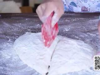 7、春日田园披萨,用刮板把面团转移出来放案板上，从中间切开一分为二