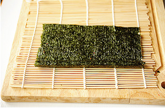 5、创意无限的花样寿司【小花寿司】,撤掉寿司帘,将多余海苔切掉;