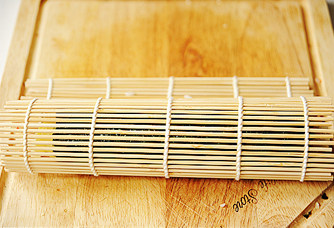 12、创意无限的花样寿司【小花寿司】,借助寿司帘,将其紧紧的卷起,收尾处的海苔若是翘起来,可以用沙拉酱作粘结剂,最后用沾了水的利刀切开即可。