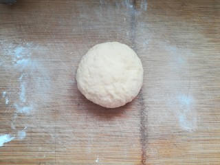 12、自制披萨,把面团移到案板上,用手揉搓排去空气,揉圆。