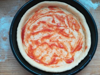 17、自制披萨,在底部抹上一层番茄酱。