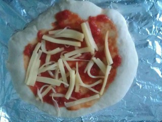 9、培根披萨,饼皮略微上色,拿出来涂上一层披萨酱,薄薄撒上一层马苏里芝士