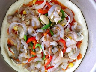 7、鲜虾蘑菇披萨,撒上蔬菜然后放虾肉。