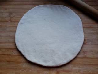 6、海鲜披萨,醒发好的面团擀成比九寸圆模底稍大一点的圆片。