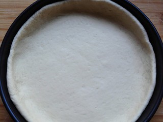 8、海鲜披萨,放入面皮，让四周稍微折起一点，再稍微醒发十分钟左右。