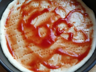 10、海鲜披萨,放入番茄沙司抹匀。