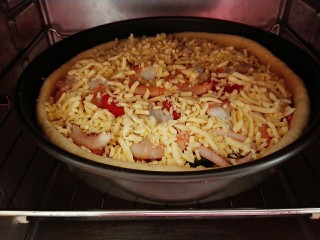 18、海鲜披萨,第二次放入烤箱，大约烤十分钟左右，看到奶酪融化表面成金黄色就好了。