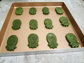 14、抹茶油酥饼干,直到印好全部的面团（擀一个圆，印几个，剩下的再擀，再印，）我这是28*28的不粘烤盘，如果家里是一般的烤盘，可以垫一张油纸，防粘