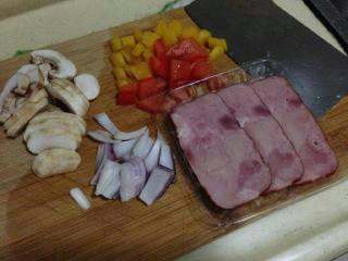 1、吐司披萨,培根切片，蘑菇洗净切片，彩椒、洋葱切丁。