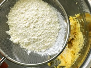 4、芒果曲奇,把低筋面粉筛入黄油糊;