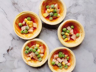 4、蛋挞皮披萨,放入香肠丁，放入玉米豌豆粒