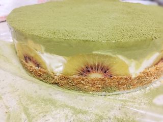 23、抹茶双味芝士生日蛋糕,四小时后取出蛋糕脱模，脱模之前用吹风机沿模具四周稍吹一下，取高于蛋糕模具的东西放在模具底板 试着轻轻将蛋糕脱模！猕猴桃装修外面是不是很漂亮呀！