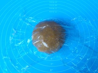 7、小熊饼干,用手抓捏成团，放案板上，盖保鲜膜醒面15分钟。