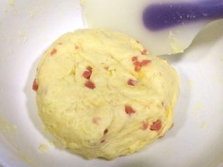 8、芝士香肠司康,继续用刮刀翻拌均匀成团（也可以直接用手揉捏成团），盖上保鲜膜入冰箱冷藏20分钟。