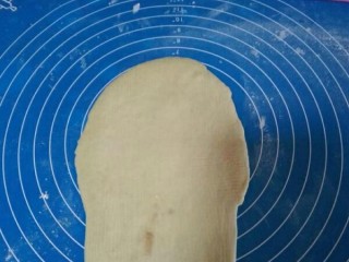 9、网纹红豆面包,将另外一个大面团擀卷成椭圆形。