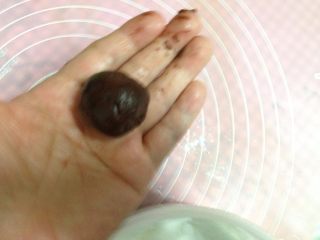 8、可可裂纹曲奇,取出冷冻好的面团，用小勺取一块面糊，用手搓成圆球，如果搓好的面团软化得厉害，建议再次放入冰箱冷藏一段时间，否则烤出来的裂纹会不漂亮！