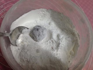 9、可可裂纹曲奇,放入装有糖粉的碗里，用勺子使其全部裹住糖粉，一定要沾均匀哟