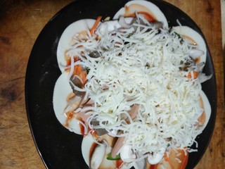 7、剩饺子皮做的披萨，味道很赞哦,最后加厚厚的芝士多加才拉丝，一定放可以放烤箱的盘子上摆，要不饺子皮不好移动，因为我第一个就费劲的移动有些散，我放入微波炉里40分钟，中间停一次，我动看看，又接着烤的，第一个30没熟，45分又些干，所以40分钟，我家的刚刚好