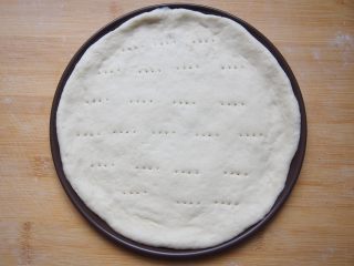 7、番茄鸡肉肠披萨,用叉子叉上一些小孔，加盖醒发15-20分钟。