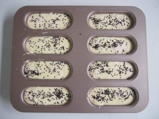 12、椰蓉蛋糕,在蛋糕糊表面撒上剩余的椰蓉，再撒上一层黑芝麻。中下层上下火，30分钟左右熟透即可，烤好后出炉震一下，倒扣晾凉后脱模