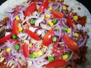 19、萨拉米白香肠培根薄底披萨(平底锅版),然后依次铺上馅料,萨拉米碎,白香肠丁,培根碎,口蘑片,洋葱丝,樱桃番茄块,青豆玉米粒。