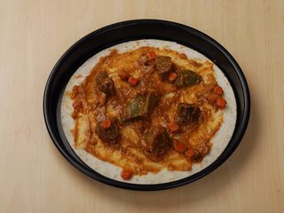 4、法式牛腩薄脆披萨,用勺子酱焗饭酱在饼底上铺均匀