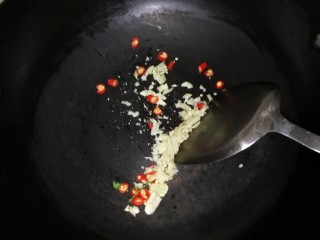 14、连骨头也不放过——秘制酸辣鸡爪,干锅小火，放入蒜米和辣椒圈稍微煸干水分。