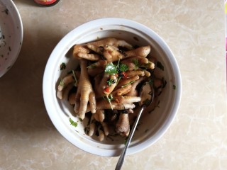 18、连骨头也不放过——秘制酸辣鸡爪,撒入香菜叶，轻轻搅拌翻匀。