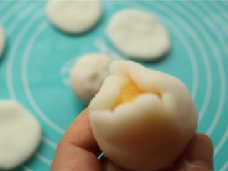 15、fluff草莓味棉花糖奶黄冰皮月饼,虎口收口法包好，收口捏紧。